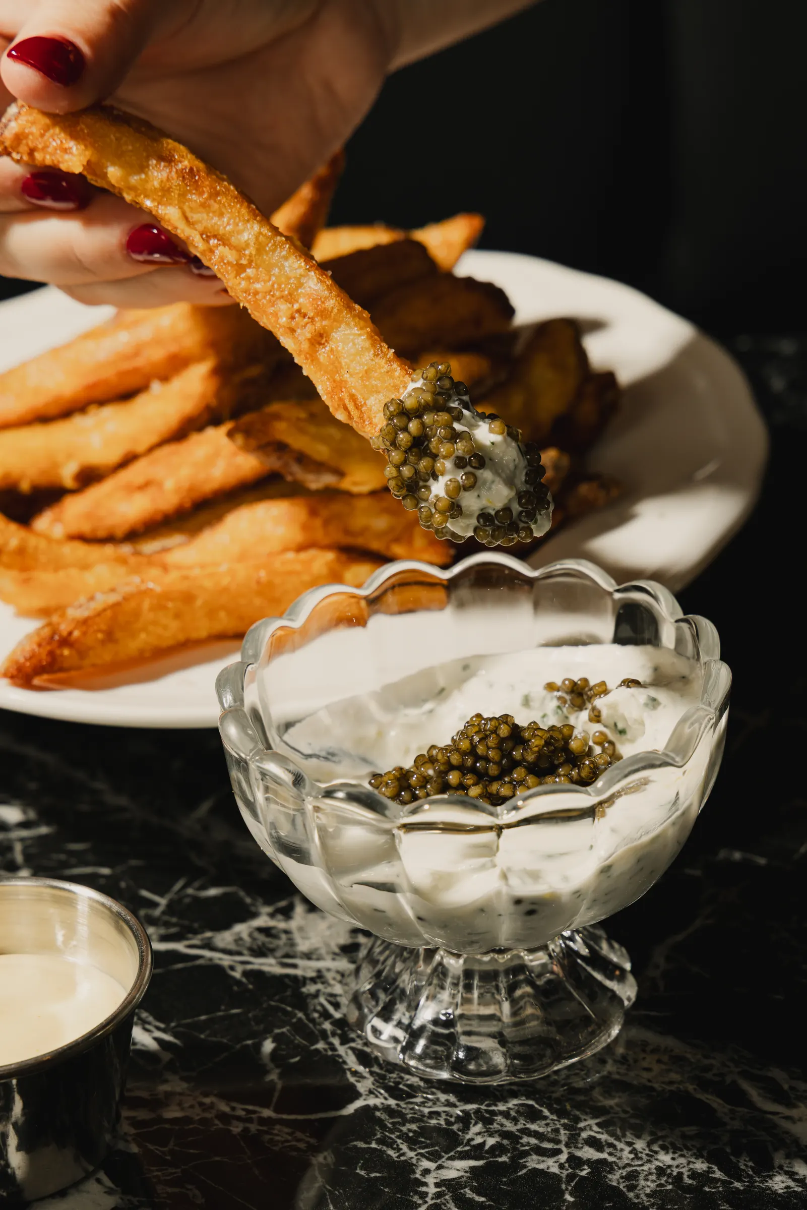 Frites dipped in caviar and crème fraîche