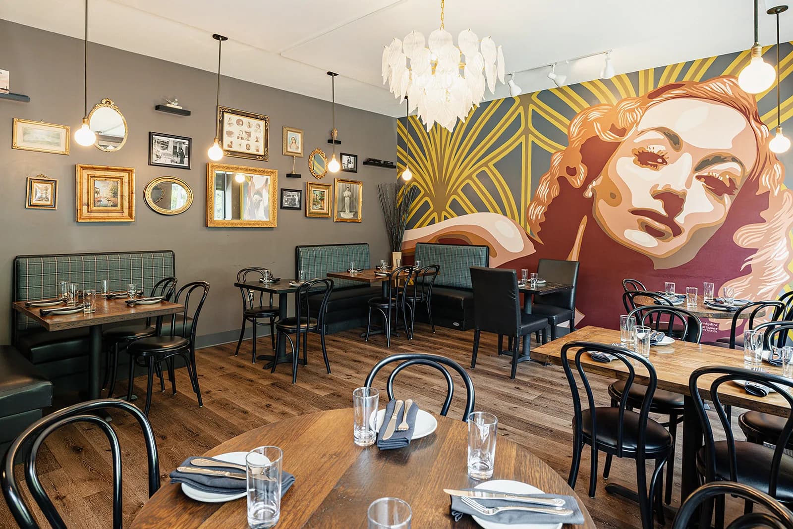 The dining room at Losanti – Cincinnati beneath its art deco mural and chandelier