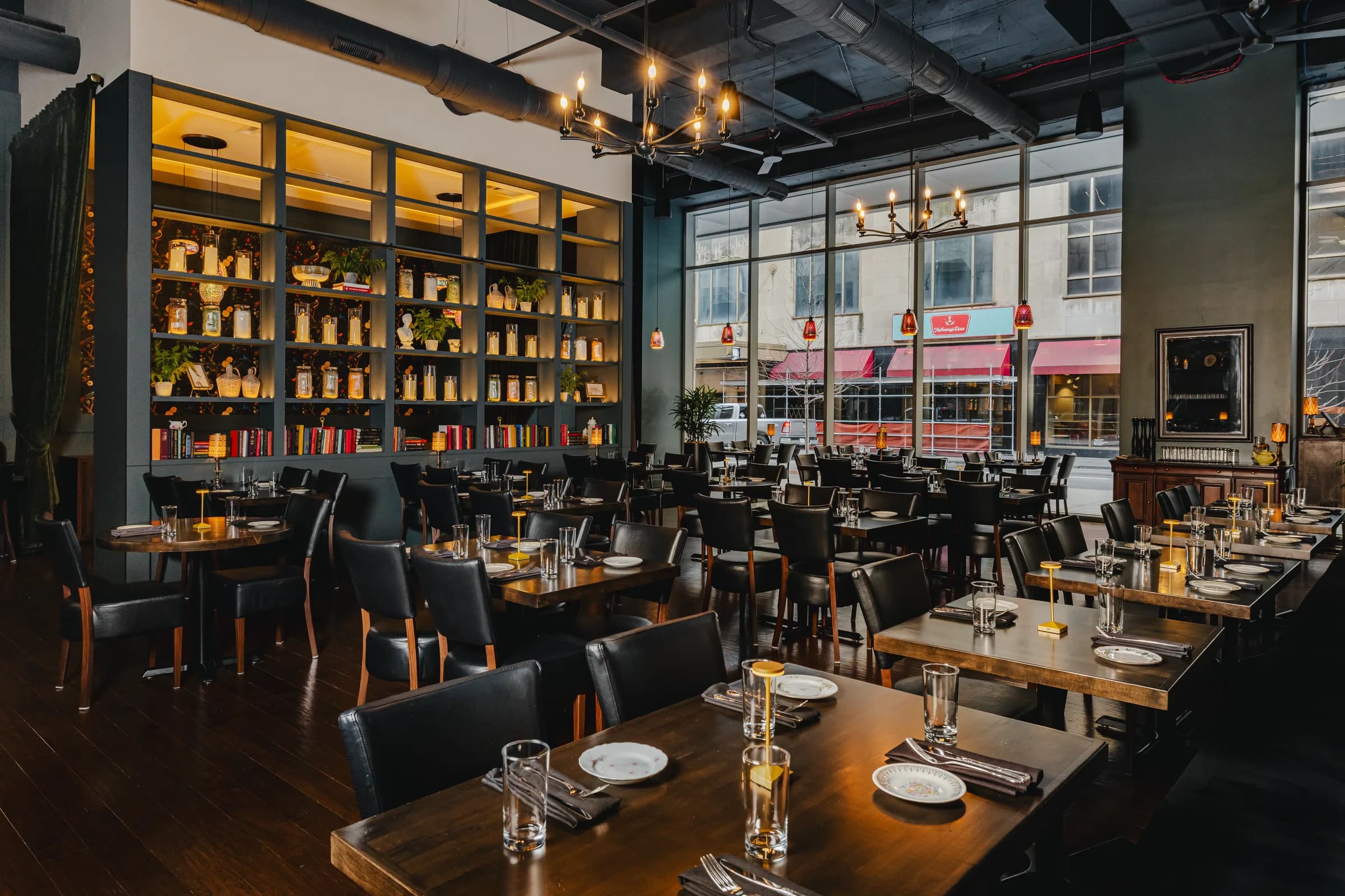 The dining room at Marigold, tables set along the windows with the back bar running the length of the room