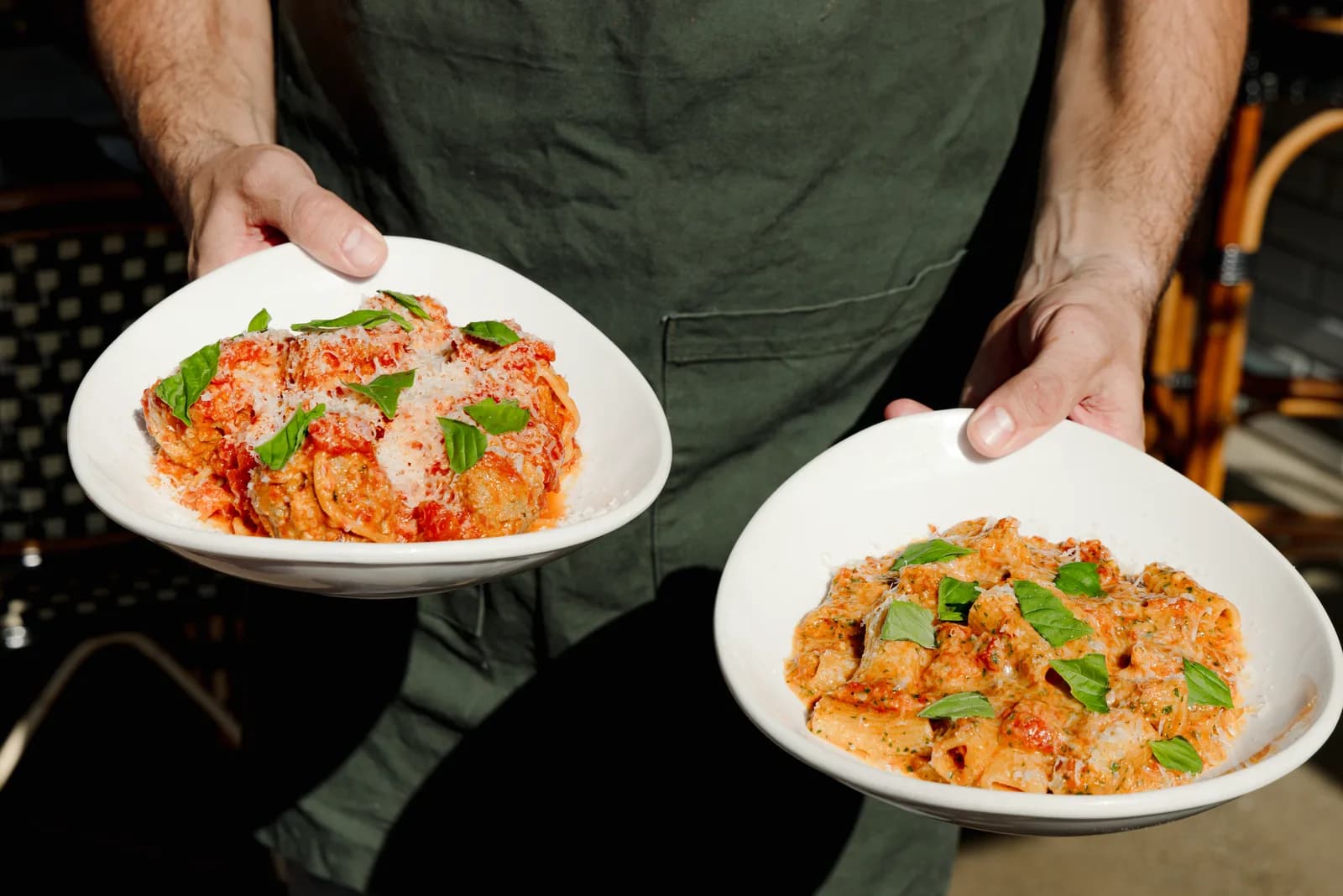 Two plates of pasta carried out to the table